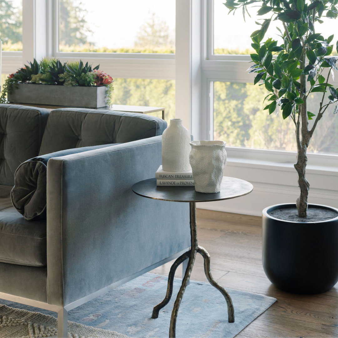 CG Hunter metallic antique side table, succulents, and faux tree are examples of the importance of home decor