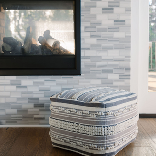 Elegant Square Handwoven Stripe Loop Ottoman Pouf by CG Hunter, styled beside a modern fireplace, demonstrating versatility and natural texture for contemporary decor.