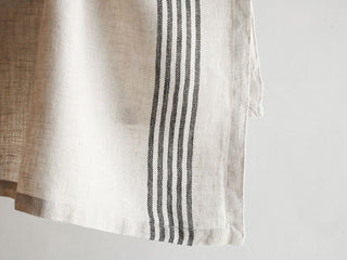 Close-up detail of CG Hunter Striped Napkins showcasing the unique black and ivory striped design on natural linen, emphasizing luxury and craftsmanship.