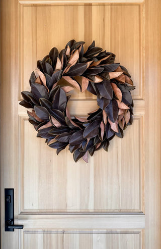 30" Faux Brown Magnolia Leaf Wreath by CG Hunter adorning a wooden door, accentuating seasonal decor with elegance and sophistication.