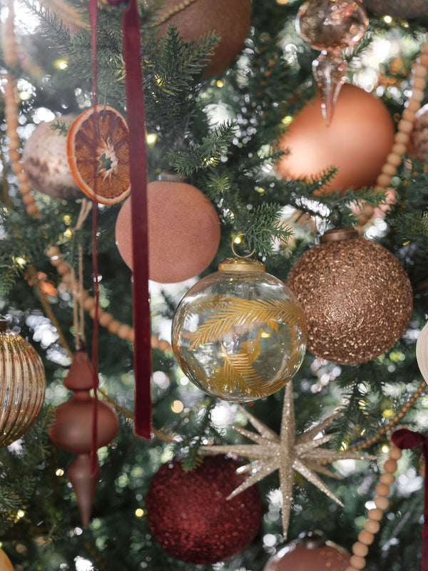 a photo of the beautiful glass handblown ornament with gold etching on a holiday tree