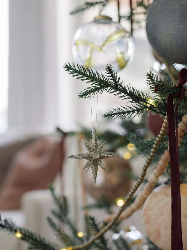 Starburst ornament on beautiful holiday tree 