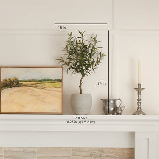 Stylish display of the artificial Olive Topiary Tree in Mediterranean Pot by CG Hunter, artfully arranged on a mantel next to a painting, enhancing the luxurious home decor atmosphere.