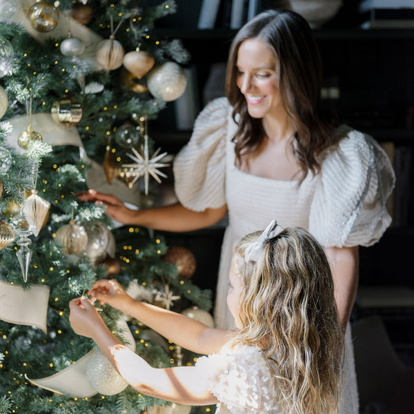 Gold Glitter Starburst on Midnight Star Collection tree with mom and daughter looking in awe