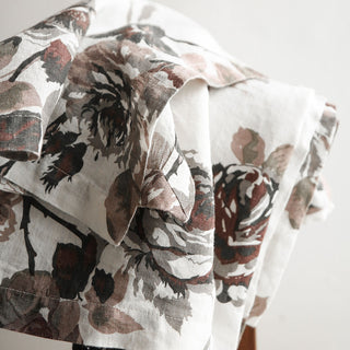 Chic presentation of the CG Hunter Handcrafted Linen Eggplant and Grey Roses Tablecloth, elegantly styled with artistic folds to emphasize its rich color and floral patterns.