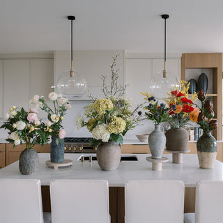 Cluttercore styling with layered florals and sculptural vessels, edited through a CG Hunter lens of intentional abundance.