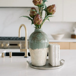 CG Hunter faux artichoke stems in a green and cream ceramic vase styled on a kitchen counter