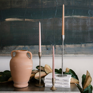 Stylish arrangement featuring a terracotta artisanal vase from the CG Hunter artisanal vase collection, paired with chic taper candles on stacked books. This elegant decor adds sophistication and charm to any space.