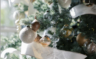 Midnight Star Collection: A beautifully decorated Christmas tree adorned with sparkling gold and silver ornaments, featuring elegant paper garlands delicately inscribed with festive greetings, creating a luxurious holiday atmosphere.