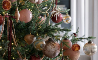 Timeless Tradition Collection: A beautifully decorated holiday tree showcasing an array of vintage rose and gold ornaments, harmoniously blending with shimmering metallics and rustic elements, embodying a modern twist on traditional decor.