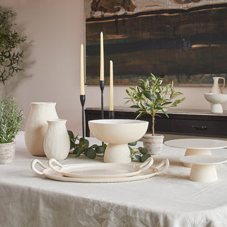 Elegant display of the Charlotte Collection by CG Hunter, featuring soft cream candleholders, a serving bowl, vases, and natural elements, showcasing the organic decor collection's timeless elegance.