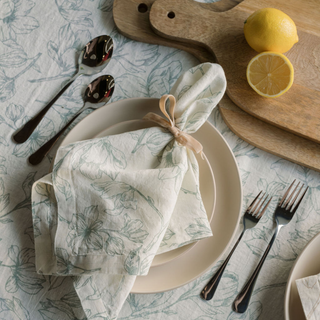 Luxurious CG Hunter Grey and Green Lilies Napkins artfully arranged on a dining table, showcasing their handcrafted beauty for an exquisite table setting.