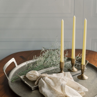 Stylish CG Hunter 3.5" Iron Candleholders in Antique Brass adorned with taper candles, creating a sophisticated table setting with a warm ambiance.
