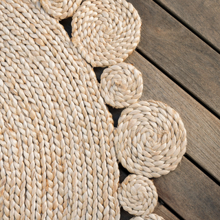 Close-up of the luxurious CG Hunter Natural Round Scalloped Jute Rug, showcasing its exquisite herringbone weave and the elegant scalloped design, ideal for enhancing any sophisticated decor.