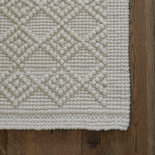 Close-up of the textured edge of the CG Hunter Handmade Natural Sisal & Wool Diamond Loop Rug, displaying its quality craftsmanship and neutral tones.