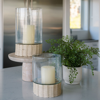 Elegant arrangement of CG Hunter Handcrafted Clear Glass and Rattan Candleholders on a modern kitchen island, complemented by a contemporary plant for a sophisticated ambiance.