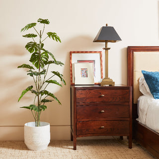 Stunning 5' Artificial Monstera Tree by CG Hunter next to a stylish bedside table with a lamp, enriching the luxury decor of a cozy bedroom.