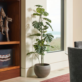 Elegant 5' Artificial Monstera Tree by CG Hunter, artfully placed in a chic stone pot, adding a touch of modern greenery to a bright interior.
