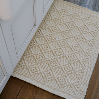 Elegant CG Hunter Handmade Natural Sisal & Wool Diamond Loop Rug positioned in a kitchen area, highlighting its intricate diamond pattern.