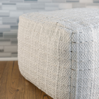Elegant CG Hunter Square Striped Woven Ottoman Pouf placed on a wooden surface, emphasizing its luxurious design and versatility.