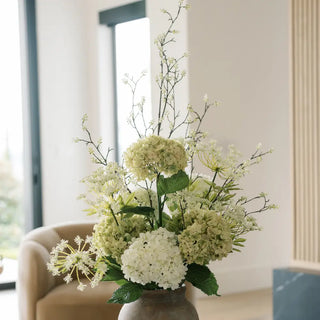 Floral arrangement in a vase on a table with a blurred indoor background