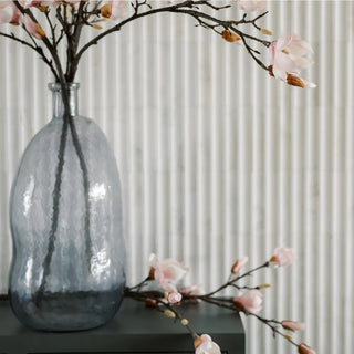 Decorative vase with floral branches against a neutral background