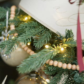 Charming arrangement of 8' Natural Wood Bead Garland by CG Hunter, intertwined with holiday décor elements, perfect for enhancing traditional festive aesthetics.