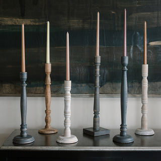 Artistic display of tapered candle holders by CG Hunter, made from dark grey wood, radiating rustic charm combined with modern sophistication in an impeccable setting.
