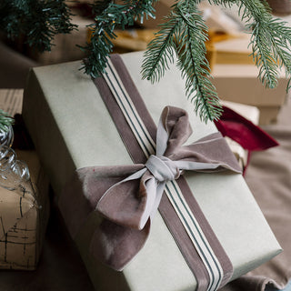 A beautifully wrapped gift featuring Wide Hand Dyed Velvet Ribbon Dark Brown 10 Yards Per Spool by CG Hunter, accented with a stylish grey bow, enhancing the festive and luxurious presentation.