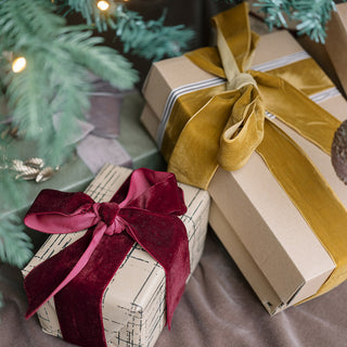 Charming holiday gifts wrapped in kraft paper and adorned with Burgundy Wide Hand Dyed Velvet Ribbon from CG Hunter, capturing the essence of luxury and style.