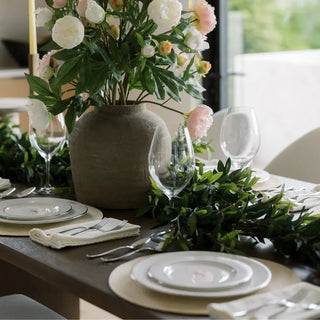 Elegant table setting with floral centerpiece and greenery