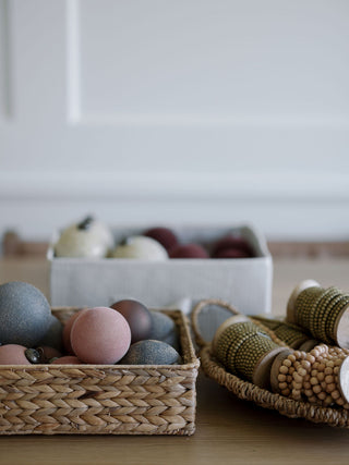 Charming arrangement of decorative ornamental balls and wood bead garlands by CG Hunter, ideal for holiday decor.
