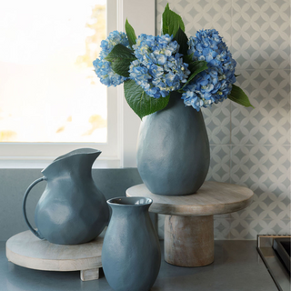 Stylish arrangement featuring the 8.5" Warm Grey Aluminum Vase with Handle by CG Hunter, filled with vibrant blue hydrangeas, enhancing a modern kitchen setting.