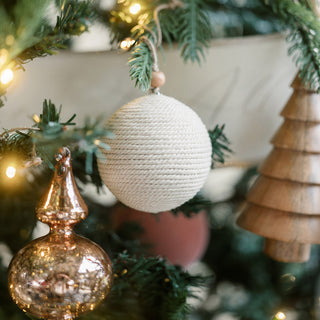 An elegant handcrafted jute ornament from CG Hunter's Natural Jute Wrapped Christmas Ornaments collection, highlighting the sophisticated design as it graces a beautifully decorated Christmas tree.