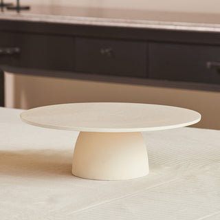 Charlotte Serving Pedestal by CG Hunter, showcasing a minimalist design with a round top and cylindrical base, ideal for elegant dining displays.