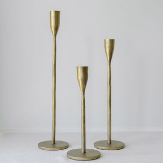 Sophisticated handcrafted antique brass candlesticks by CG Hunter, showcasing a sleek design with three varying heights, ideal for enhancing elegant settings.