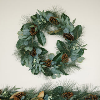 Close-up view of a stunning 28" magnolia, eucalyptus, pinecone, and needle pine wreath by CG Hunter, showcasing intricate details and rich greenery.