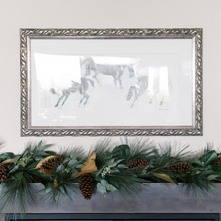 Stylish 6' Magnolia, Eucalyptus, Pinecone, & Needle Pine Garland by CG Hunter positioned above a rustic mantel, showcasing a sophisticated arrangement with framed artwork and natural elements.