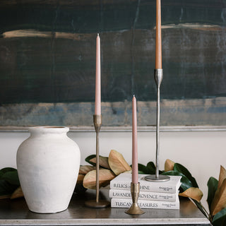 Beautiful handcrafted natural terracotta vase on buffet table with iron short and tall taper candlestick holders