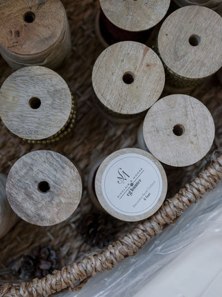 Variety of wooden spools in a rustic basket, highlighting the artisanal quality of CG Hunter's Hand Dyed Velvet Ribbon 10 Yards Per Spool – Set of 2.