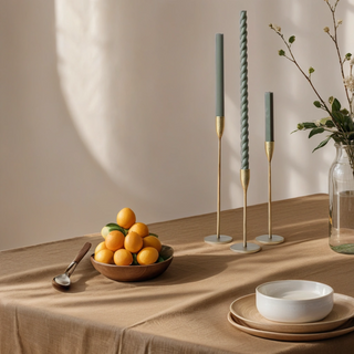 Stylish setting with handcrafted antique brass candlesticks by CG Hunter, featuring decorative candles and a beautiful arrangement of fresh fruit, perfect for upscale dining.