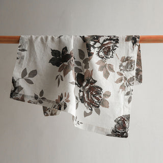 CG Hunter Handcrafted Linen Eggplant and Grey Roses Napkins beautifully draped, showcasing exquisite floral patterns in rich colors, ideal for elevating your dining experience with luxury and sophistication.