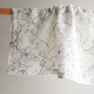 Elegantly displayed CG Hunter Grey and Green Lilies Napkin, showcasing its intricate floral design made from high-quality linen, perfect for enhancing dining experiences.