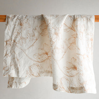 Artfully hung CG Hunter Blush Lilies Napkin displaying intricate floral design, ideal for refined table decor.