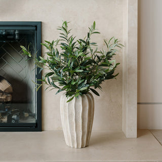 Stunning 30" Faux Olive Arrangement in Artisan Vase by CG Hunter, beautifully displayed beside a fireplace, featuring lifelike olive greenery in an elegant cream natural vase, ideal for any stylish interior.
