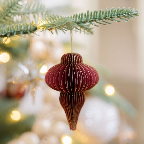Elegant CG Hunter 3" Paper Honeycomb Assorted Ornament in a vibrant burgundy shade, artfully displayed on a tree branch, emphasizing its luxurious design and festive appeal.