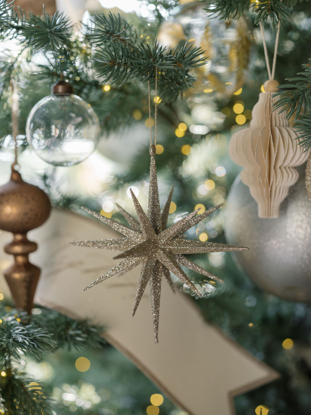 6" Starburst Gold Glitter Ornament on a beautiful tree