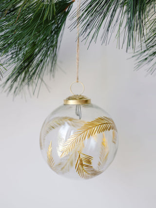 4" Artisan Glass Gold Etched Leaf Ornament by CG Hunter, elegantly hanging in a lush evergreen setting.