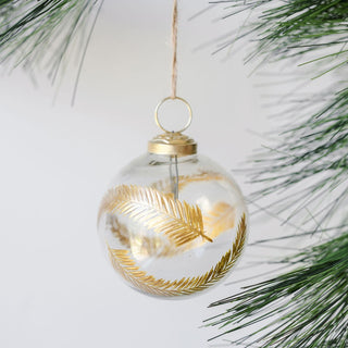 Elegant 3" Artisan Glass Gold Etched Leaf Ornament by CG Hunter, showcasing intricate gold leaf designs, suspended on a natural jute hanger amidst green pine branches.