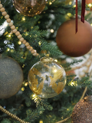 4" Artisan Glass Gold Etched Leaf Ornament by CG Hunter, delicately placed among various ornaments on a richly decorated Christmas tree.